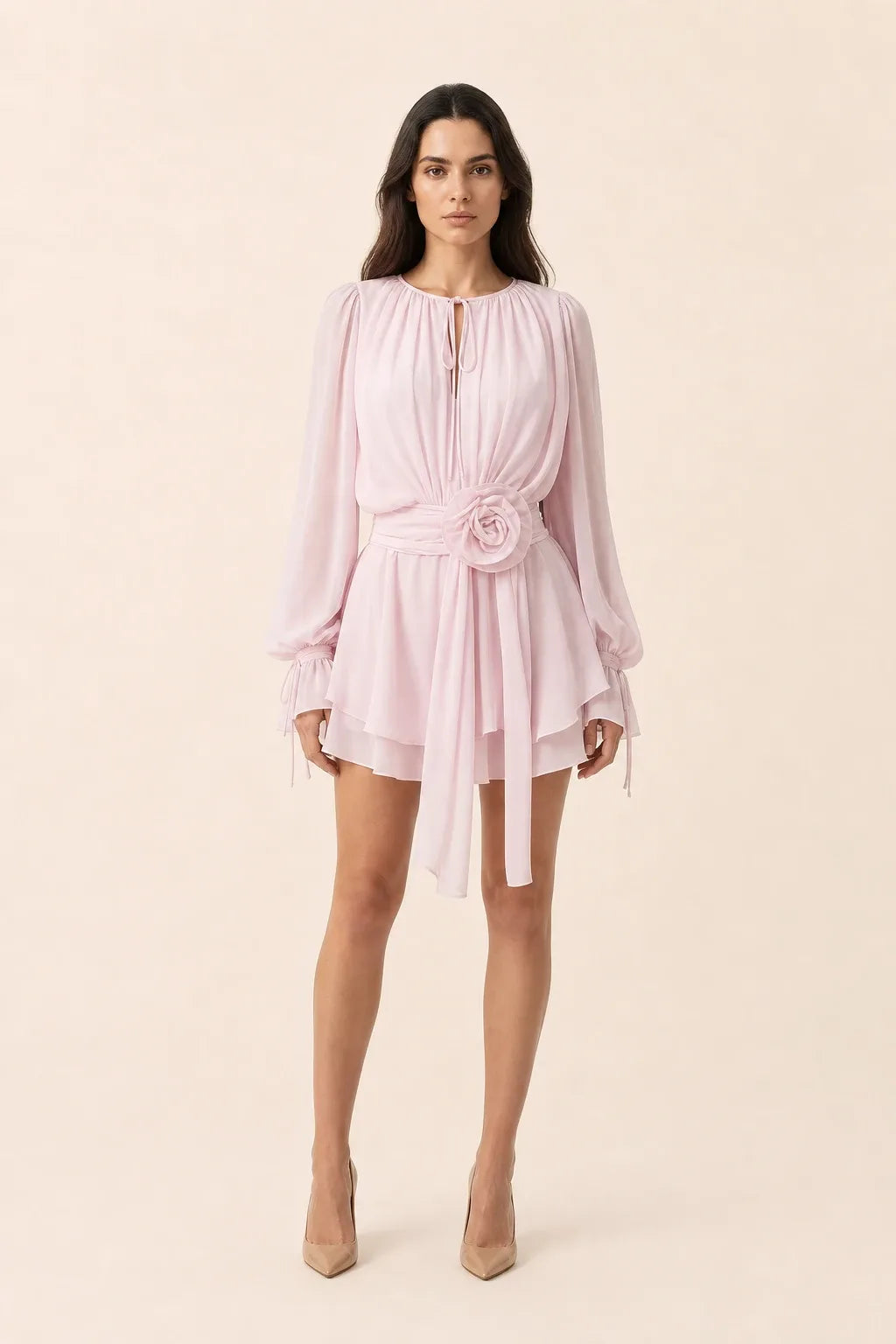 White mini dress with rosette sash detail on model in contrapposto stance
