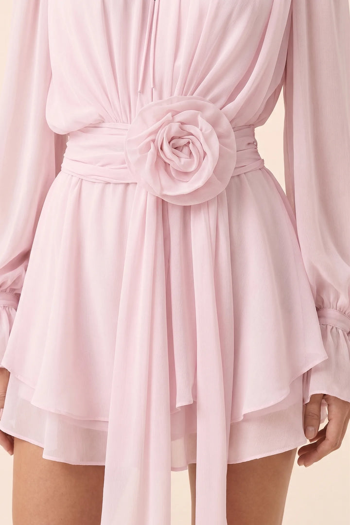 Close-up of rosette sash detail on white mini dress