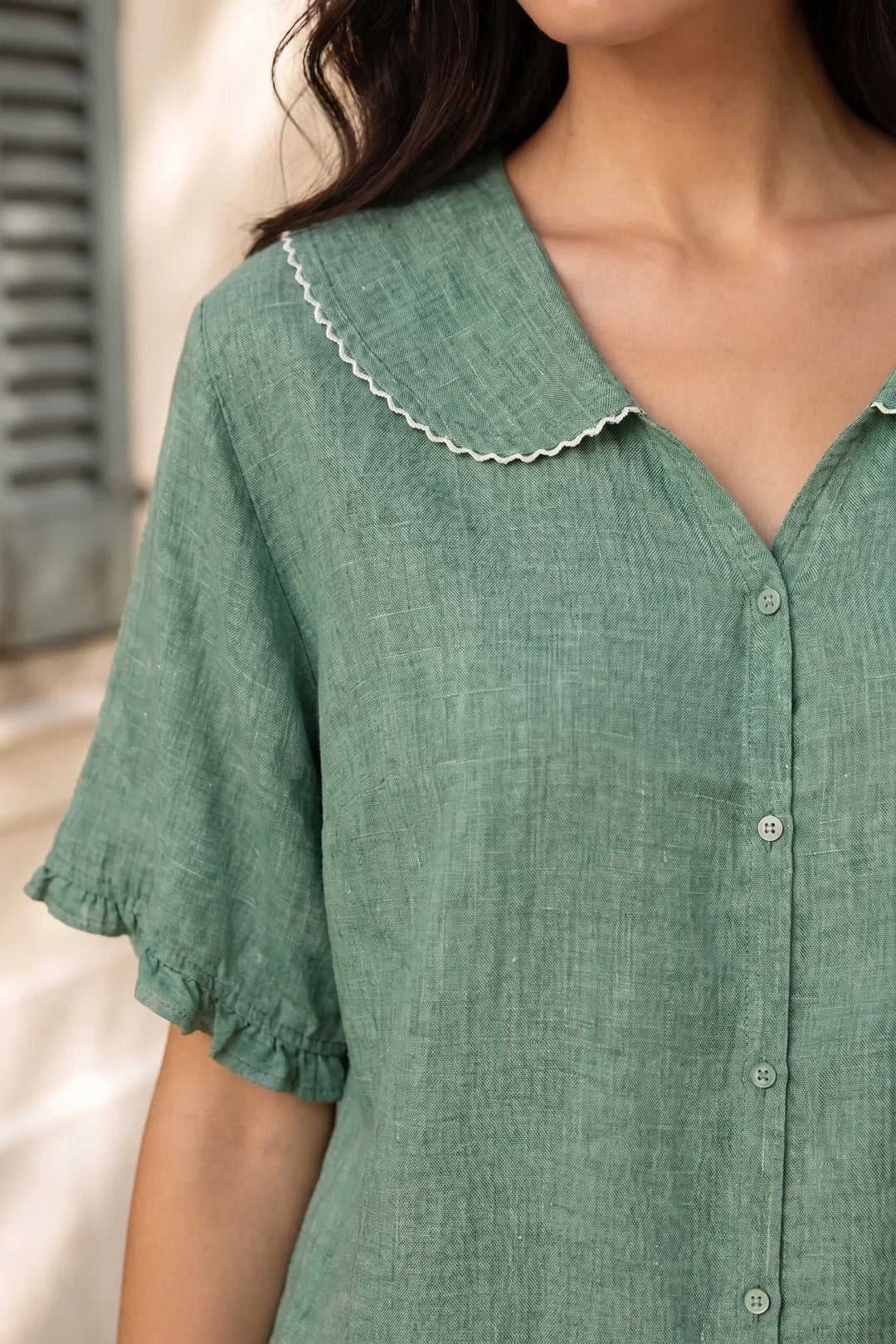 Close-up detail of green Peter Pan collar blouse
