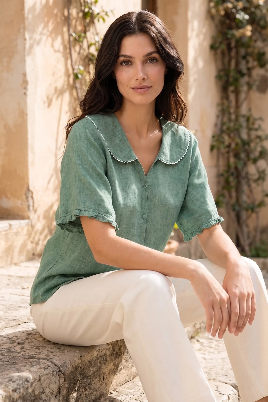 Model wearing green Peter Pan collar blouse in outdoor lifestyle setting