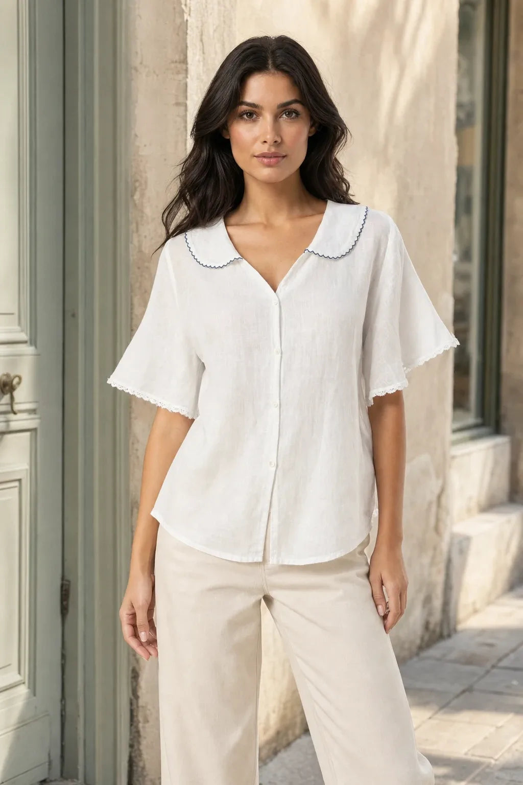 White Peter Pan collar blouse on model in contrapposto stance