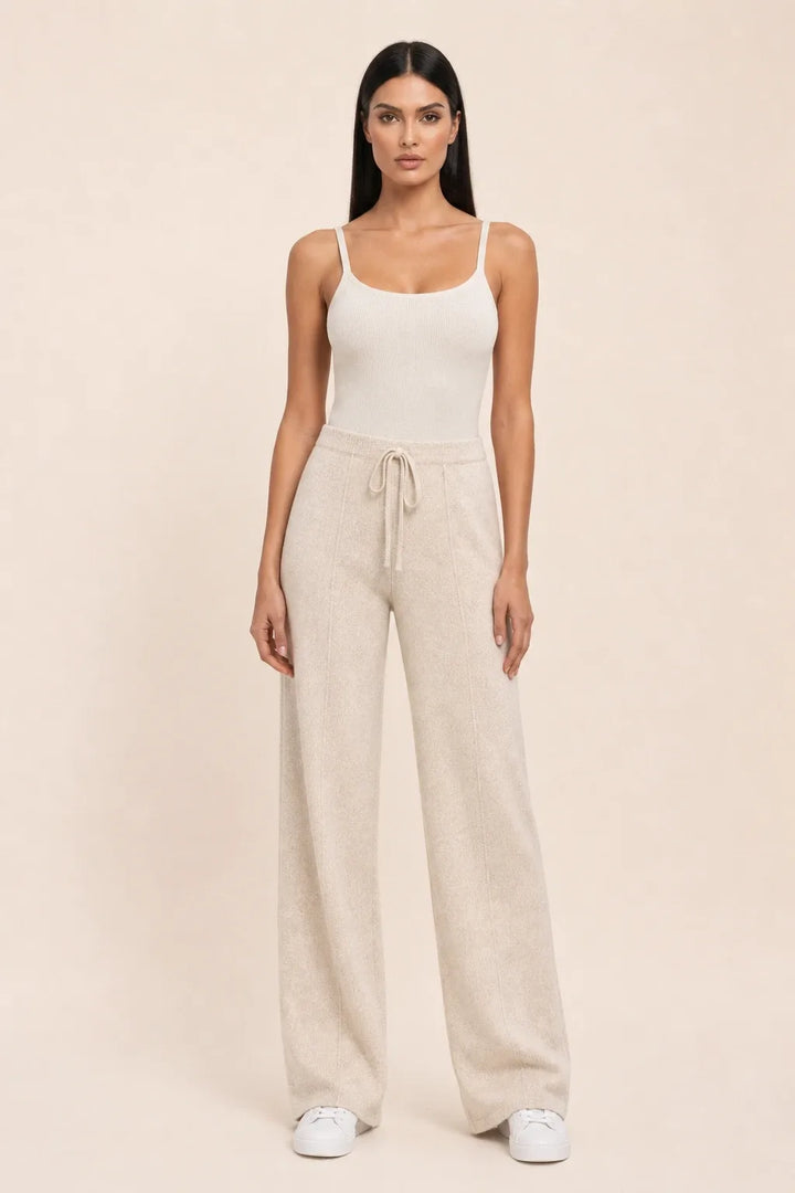 Beige knit wide-leg pants on a model in a contrapposto stance