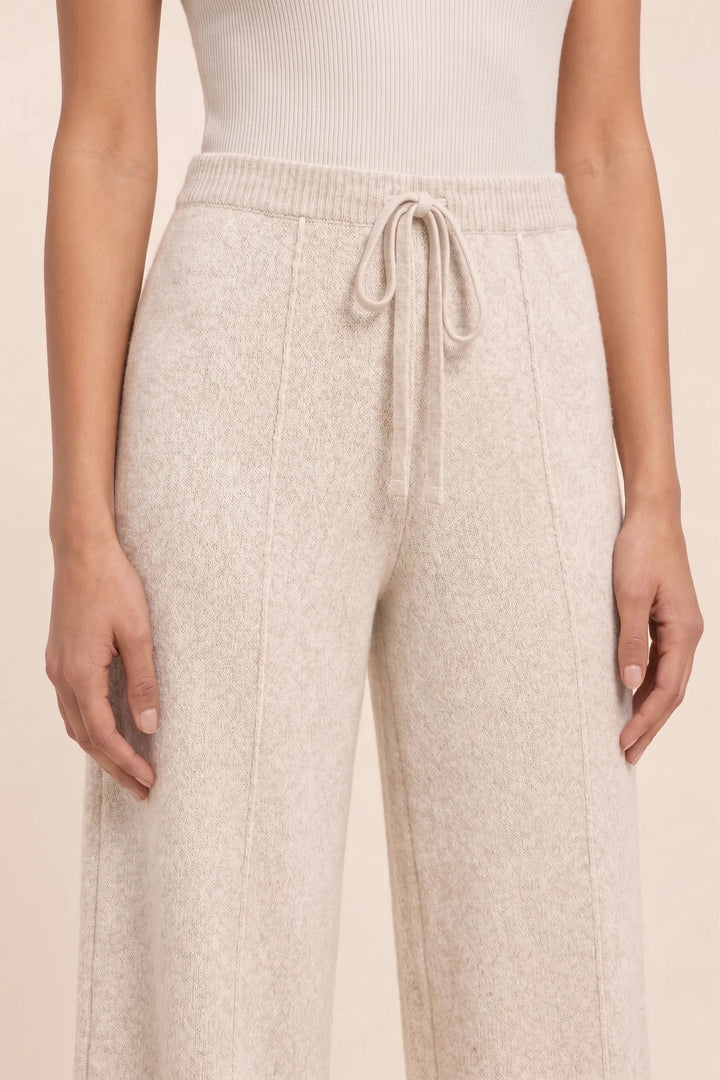 Close-up detail of beige knit wide-leg pants fabric and construction