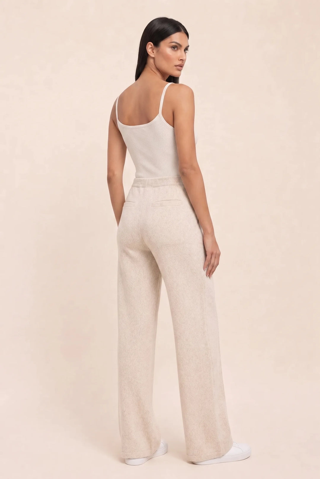 Beige knit wide-leg pants on a model in a three-quarter turn pose