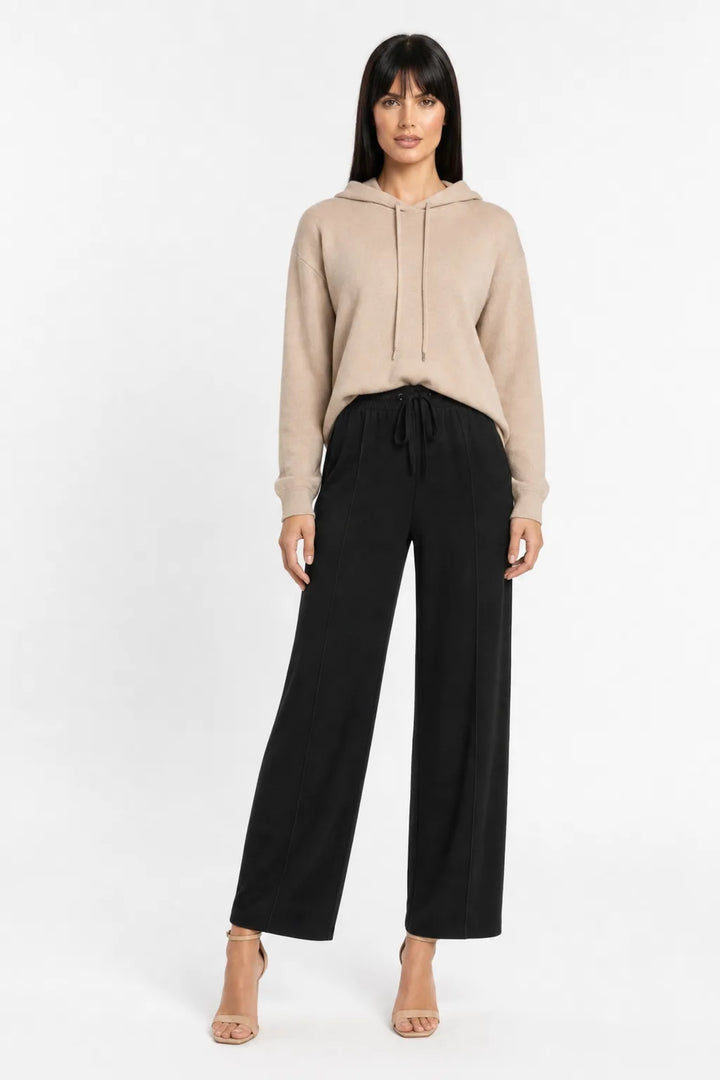 Black knit wide-leg trousers on a model in a contrapposto stance