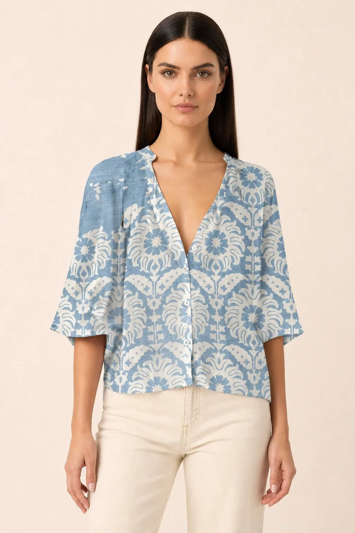 Blue floral blouse with balloon sleeves on a model in a contrapposto stance
