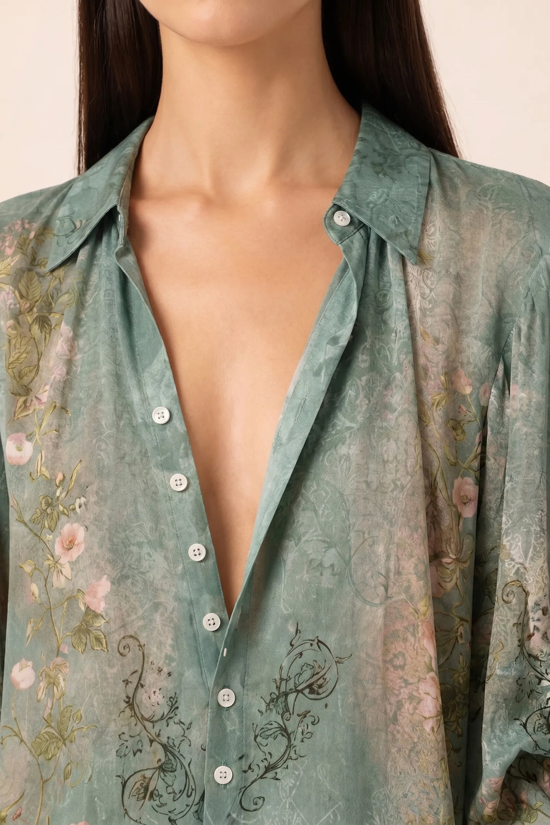 Close-up detail of a green floral blouse with voluminous balloon sleeves