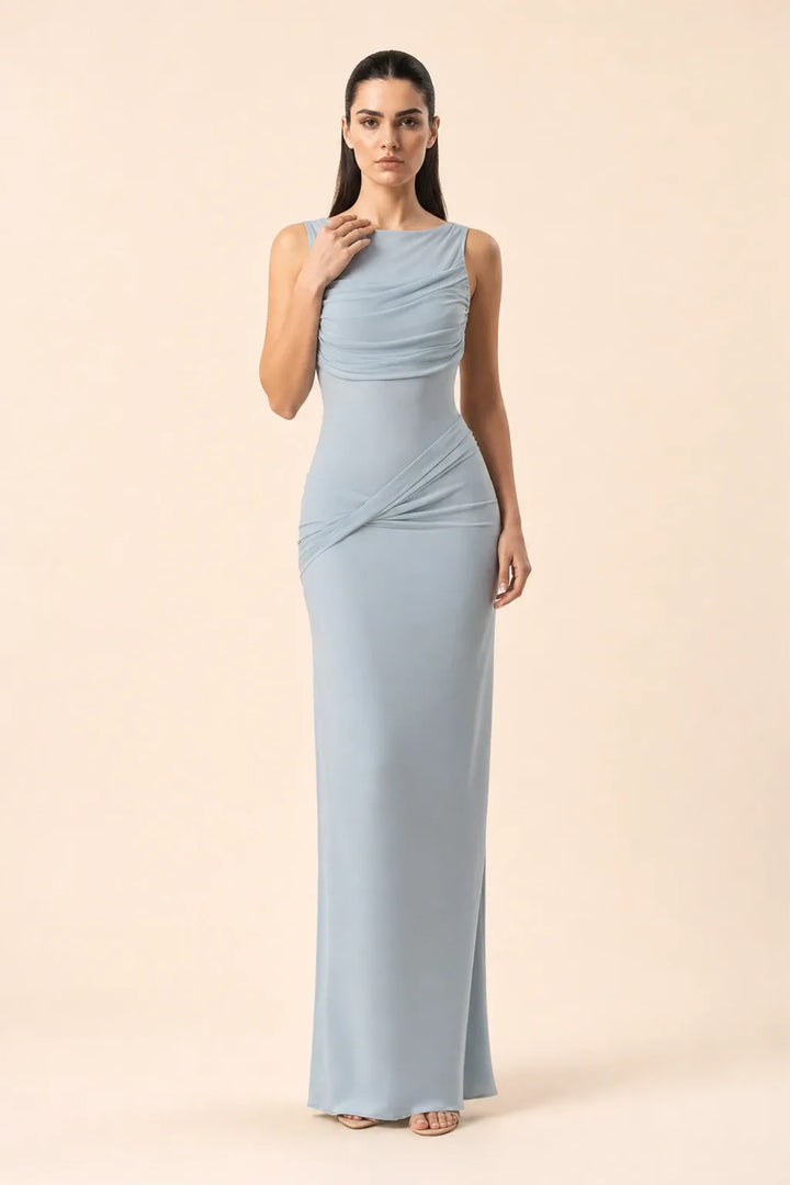 Blue ruched open-back gown on model in contrapposto stance