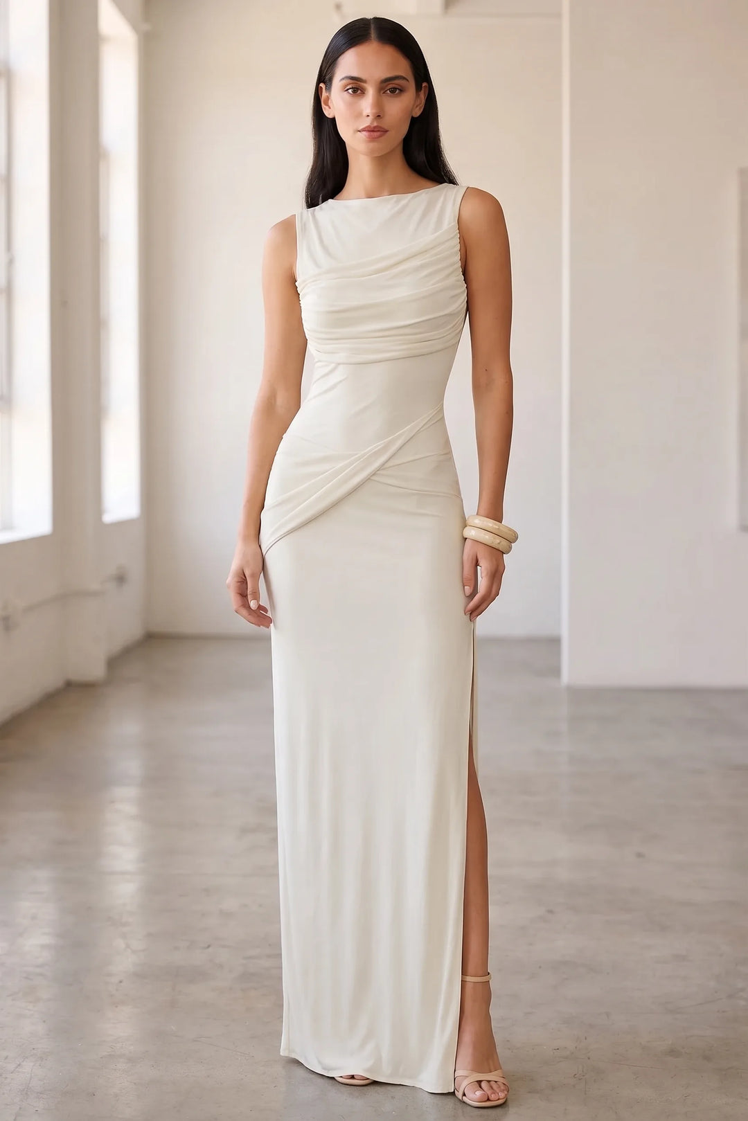 Model wearing white ruched open-back gown in lifestyle setting