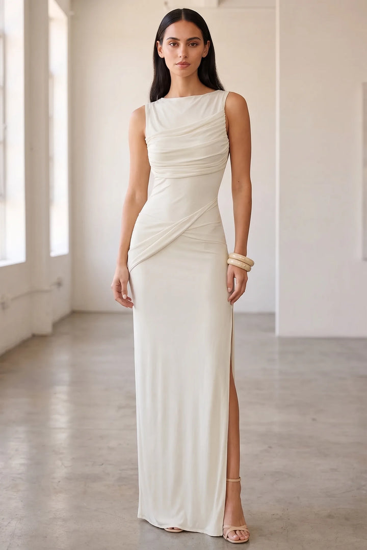 Model wearing white ruched open-back gown in lifestyle setting