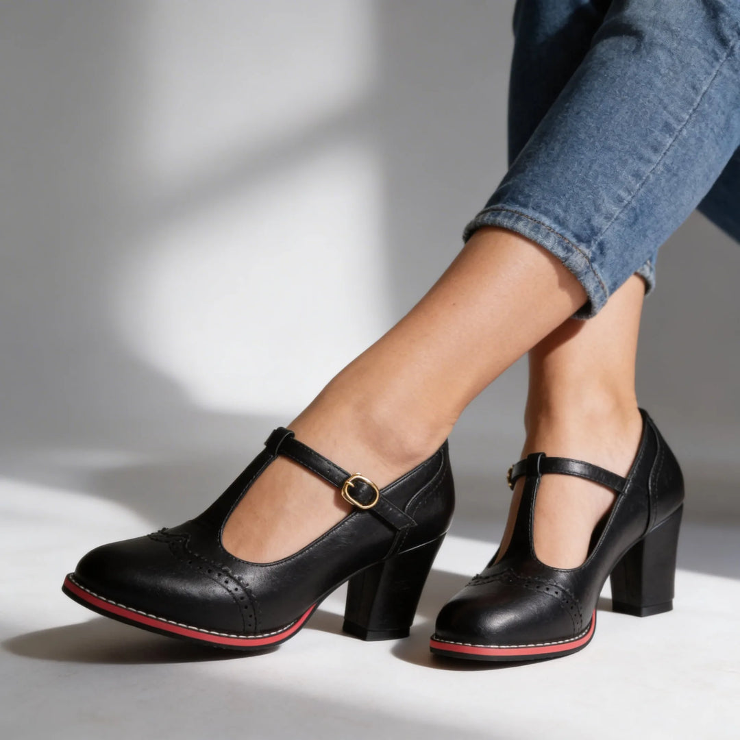 Black leather T-bar brogue pump, rear view displaying block heel height and back seam