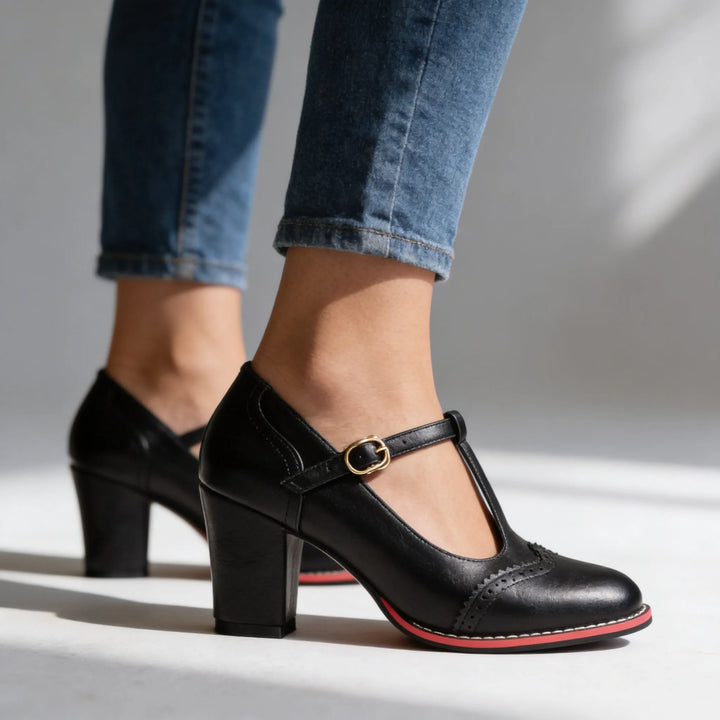 Black leather T-bar brogue pump, front view showing toe cap and perforated detailing