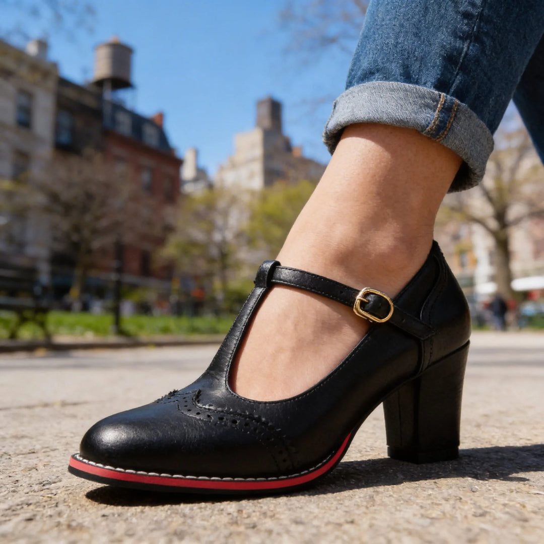 Black leather T-bar brogue pump, flat lay overhead view showing full shoe shape