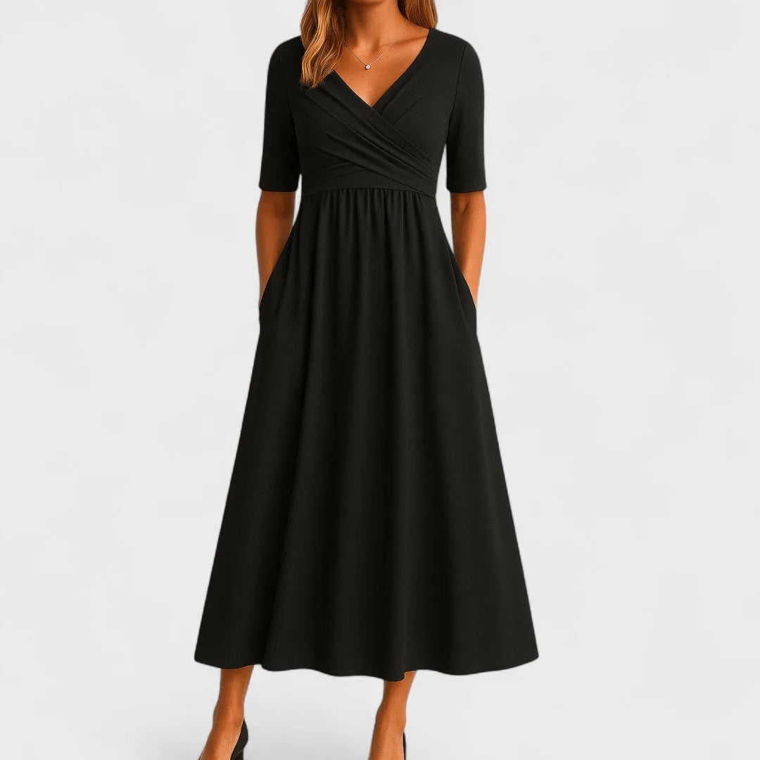 Black wrap midi dress on model in three-quarter turn, showing draped silhouette