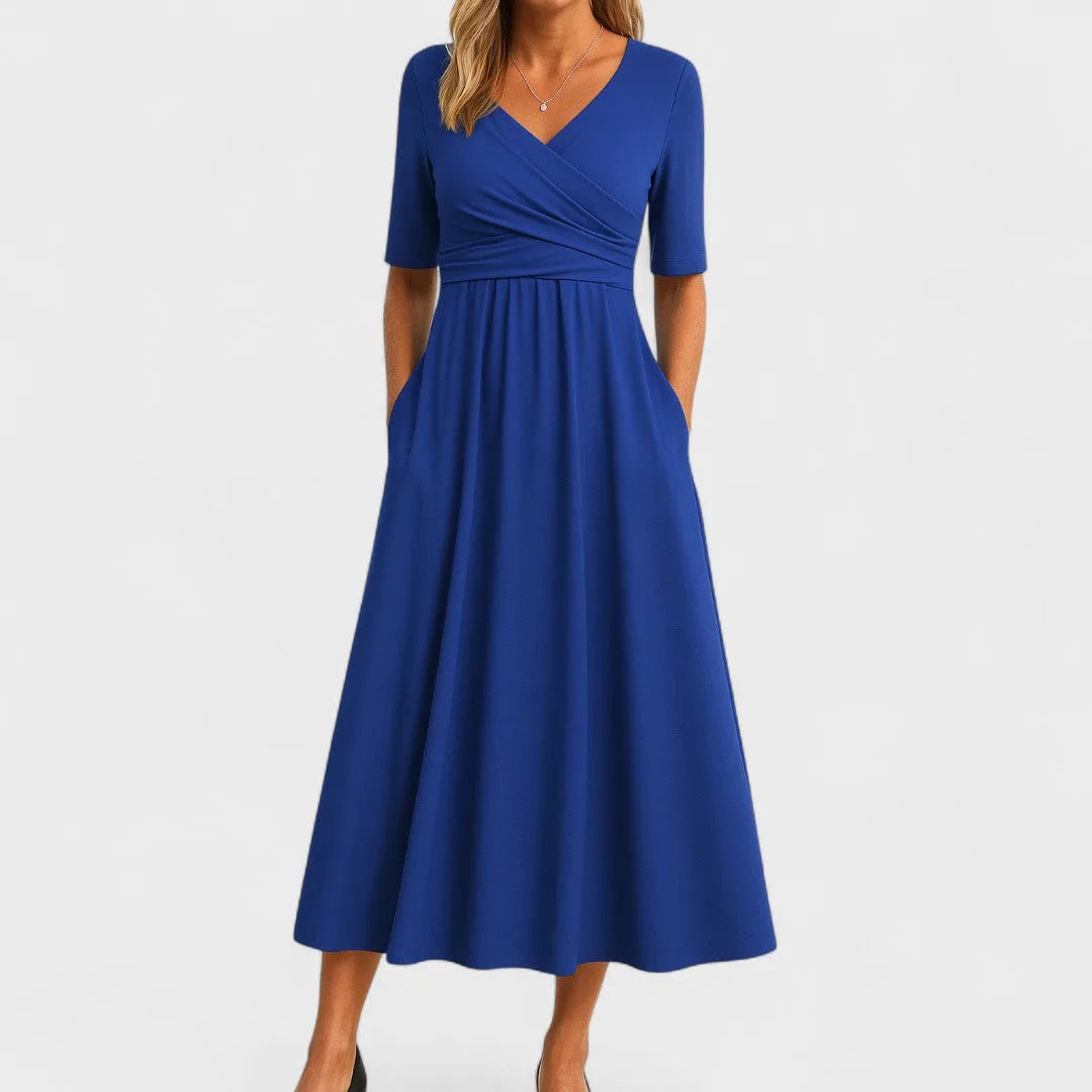 Blue wrap midi dress on model from the side, highlighting the flowing midi length