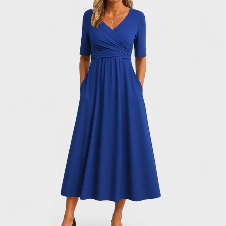 Blue wrap midi dress on model from the side, highlighting the flowing midi length