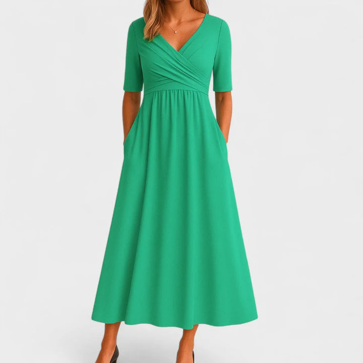Green wrap midi dress on model, V-neckline and cinched waist with flowing skirt