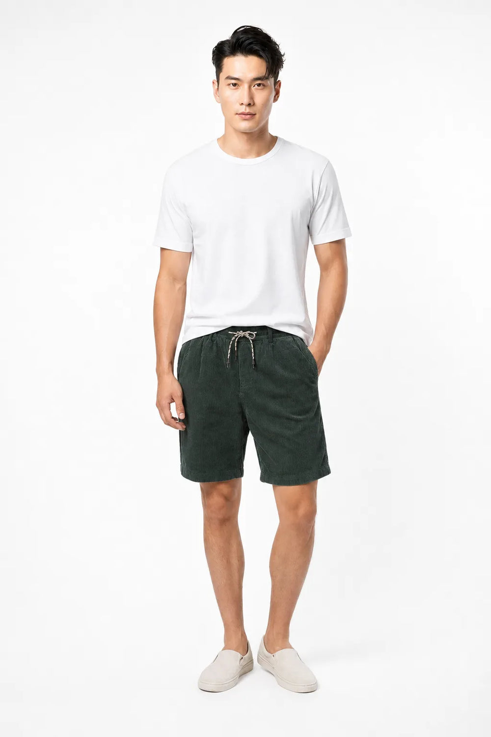 Green corduroy drawstring shorts on a model in a contrapposto stance