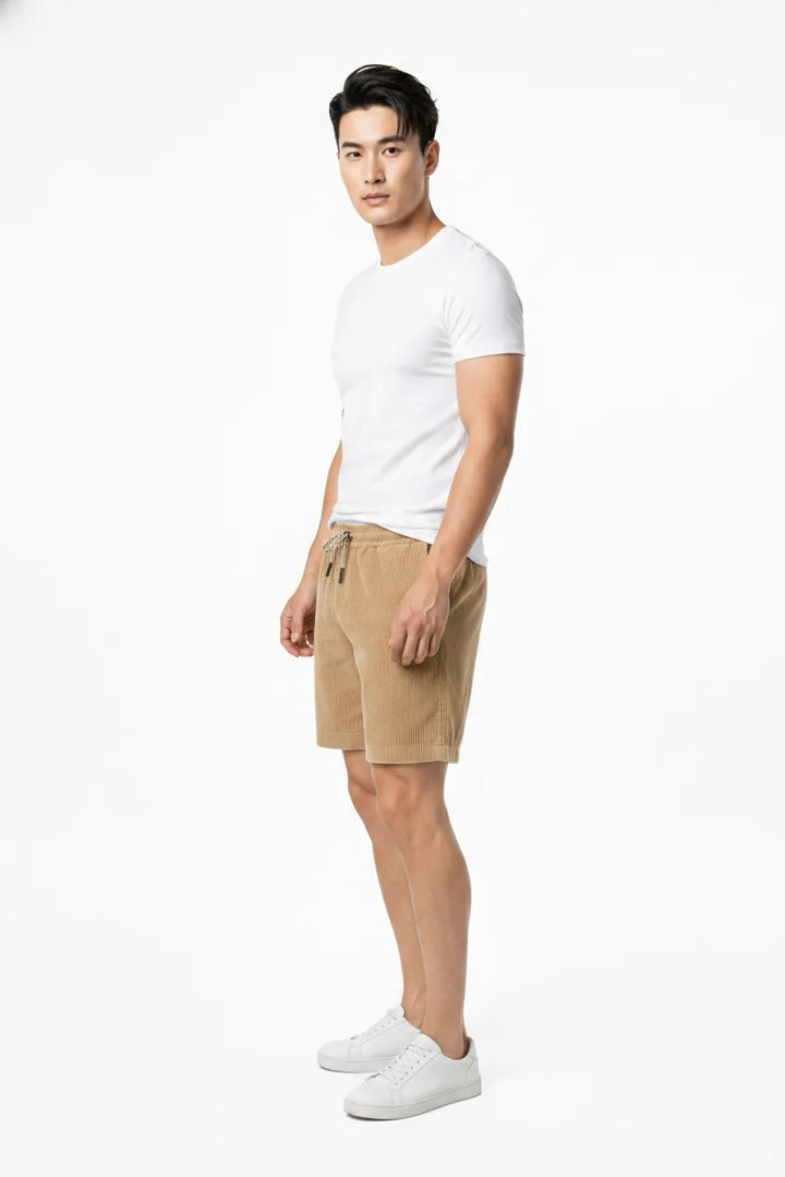 Khaki corduroy drawstring shorts on a model in a three-quarter turn