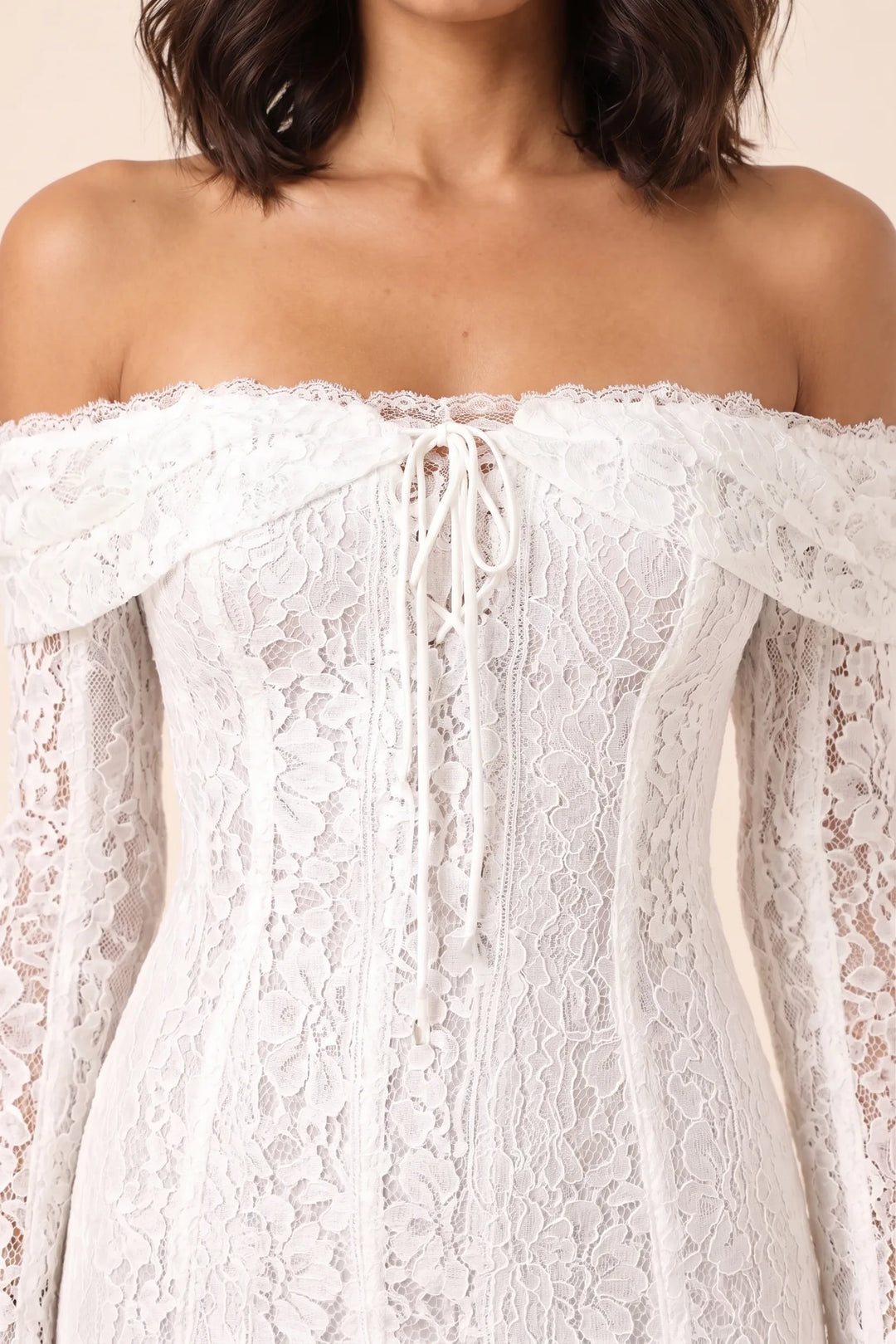 Close-up detail of white lace bell sleeve mini dress fabric and trim