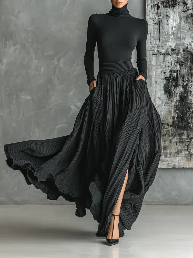 Woman facing forward in a black pleated maxi skirt set with a fitted top