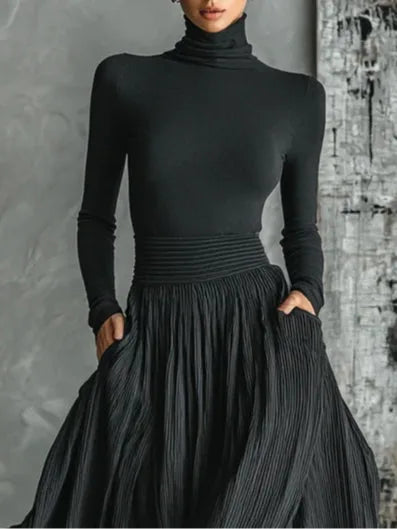 Woman in a three-quarter turn wearing a black pleated maxi skirt set