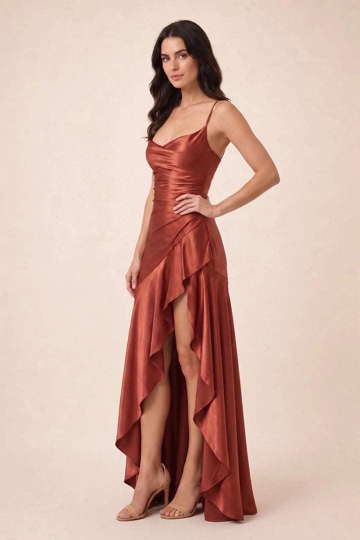 Brick red ruched satin gown on model in three-quarter turn