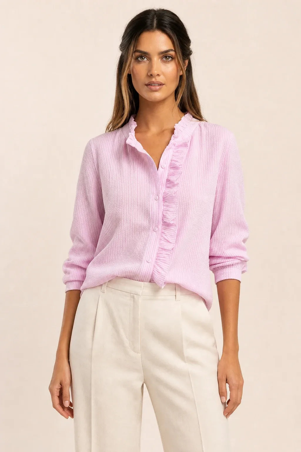 Pink ruffle front blouse on model in contrapposto stance