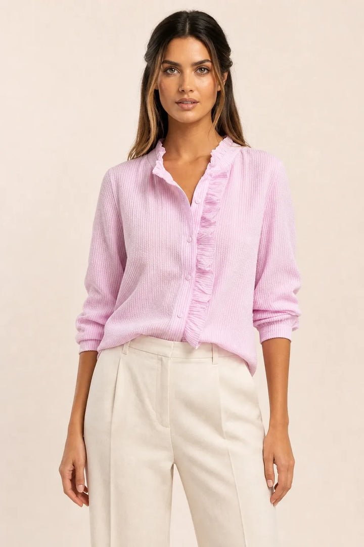 Pink ruffle front blouse on model in contrapposto stance