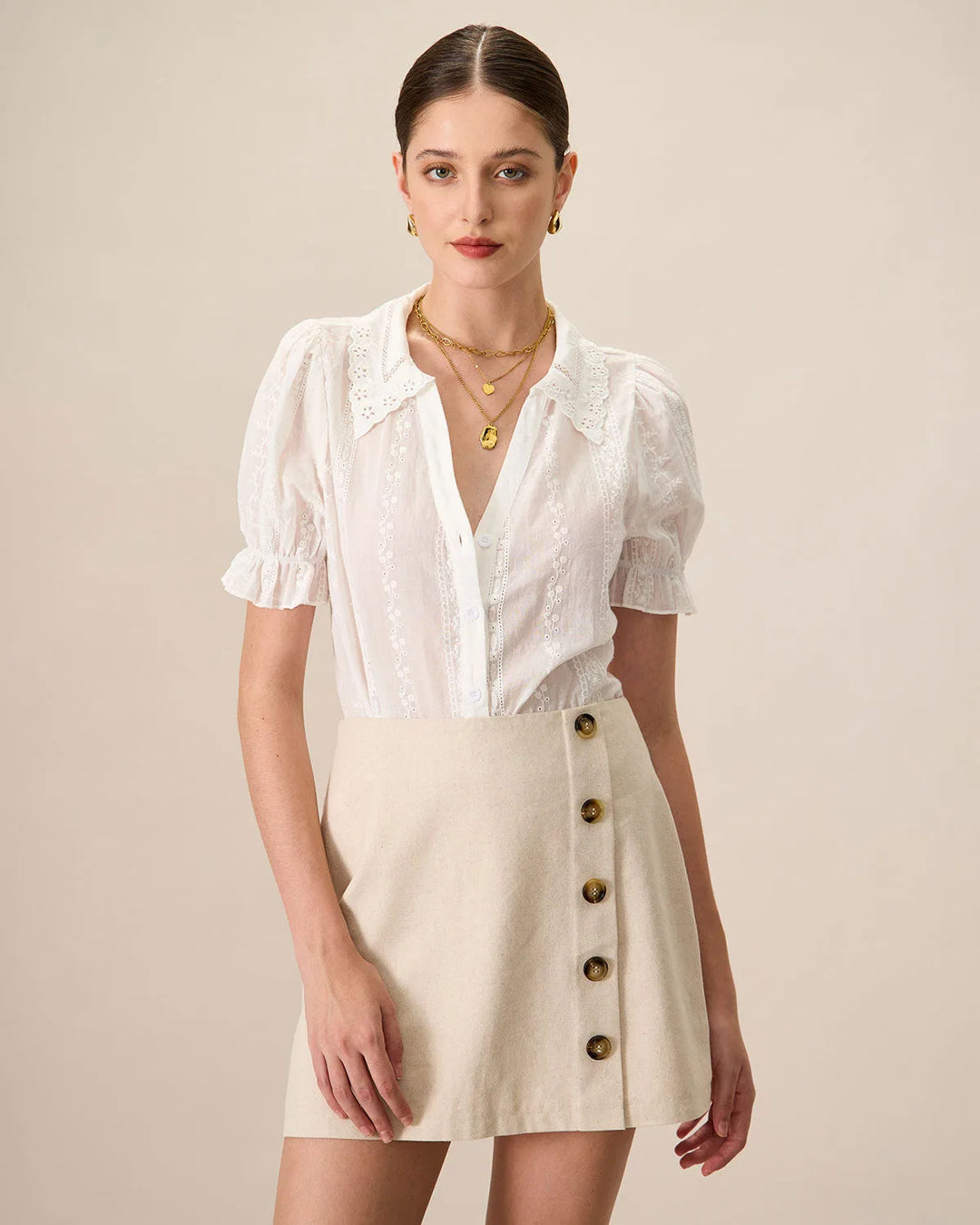White broderie anglaise blouse on model facing forward, relaxed fit with delicate eyelet embroidery