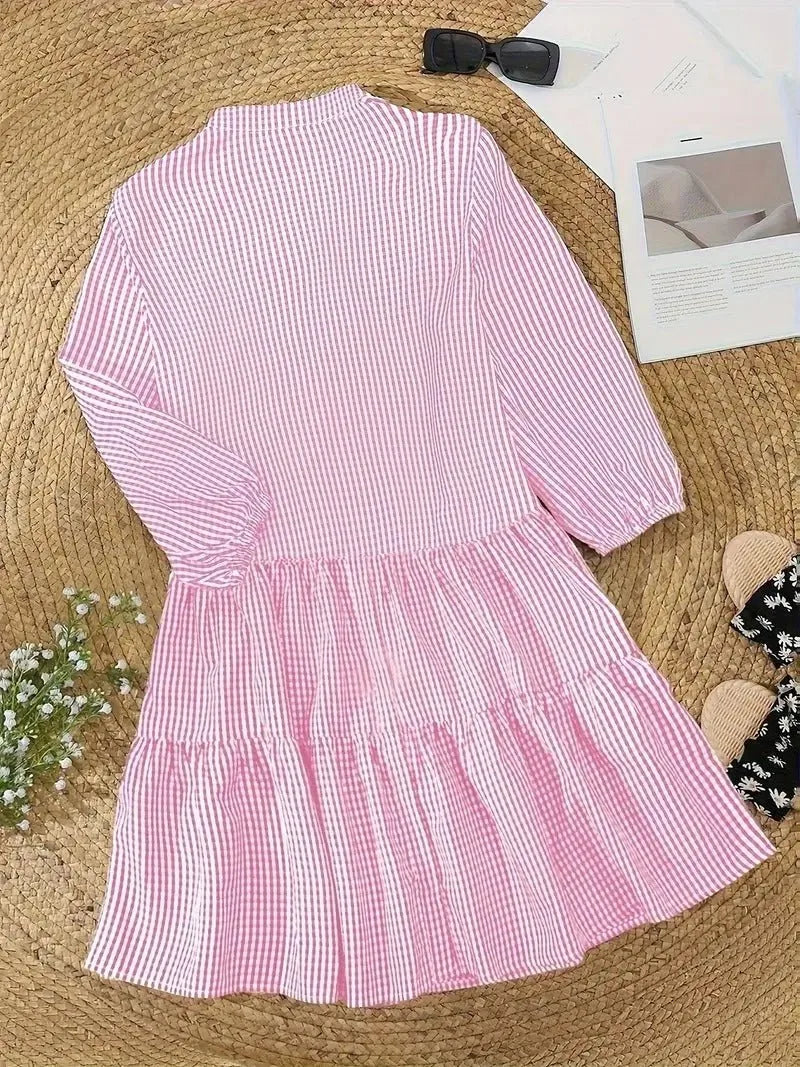Close-up detail of a pink gingham tiered mini dress fabric and tier construction