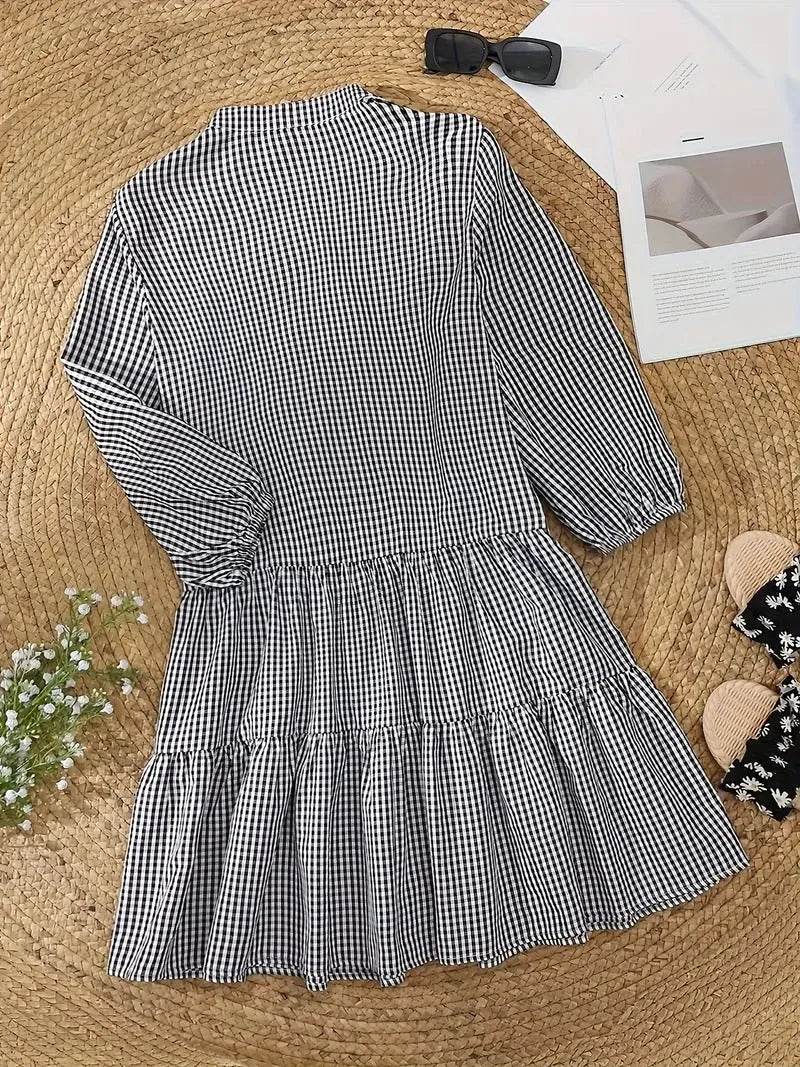 Woman wearing a pink gingham tiered mini dress in an alternate styled pose