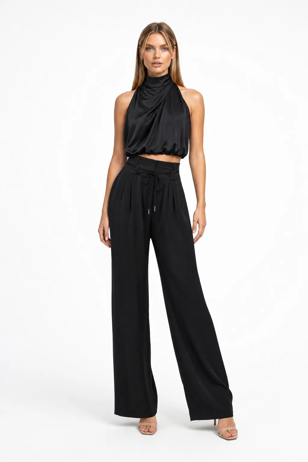 Black draped halter top and wide-leg trousers on a model in a contrapposto stance