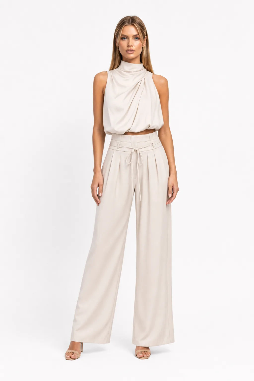Champagne draped halter top and wide-leg trousers on a model in a contrapposto stance