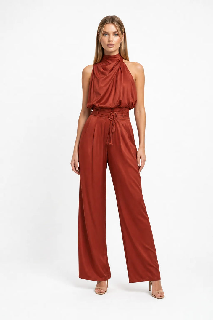 Rust draped halter top and wide-leg trousers on a model in a contrapposto stance