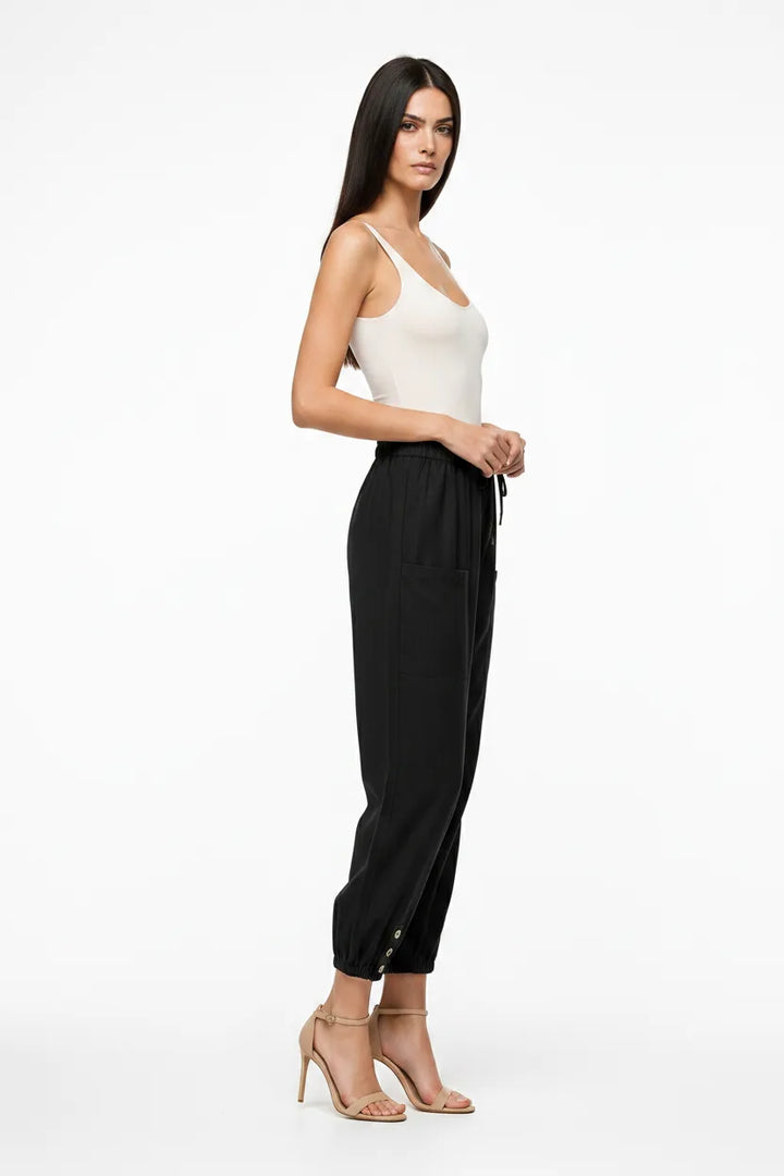Black drawstring jogger pants on a model in a three-quarter turn