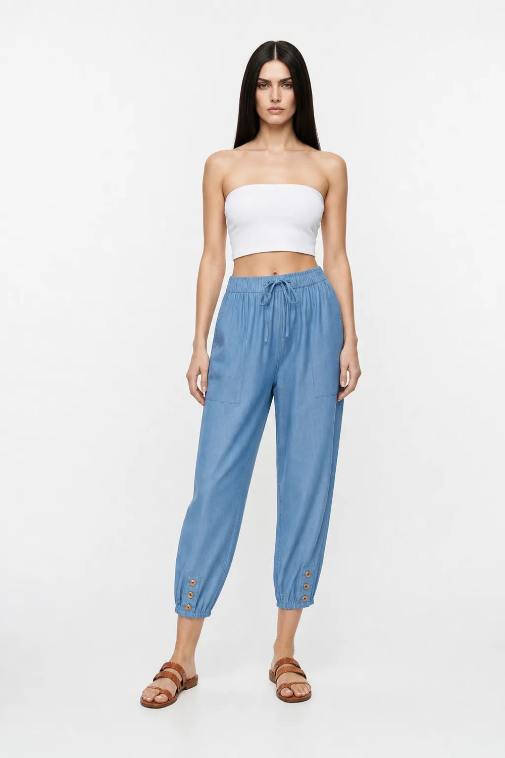 Denim blue drawstring jogger pants on a model in a contrapposto stance
