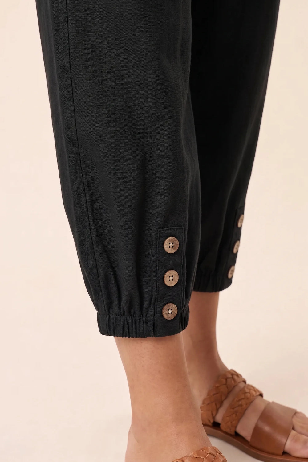 Close-up detail of black drawstring jogger pants waistband and tie