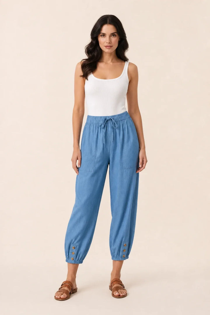 Denim blue drawstring jogger pants on a model in a contrapposto stance