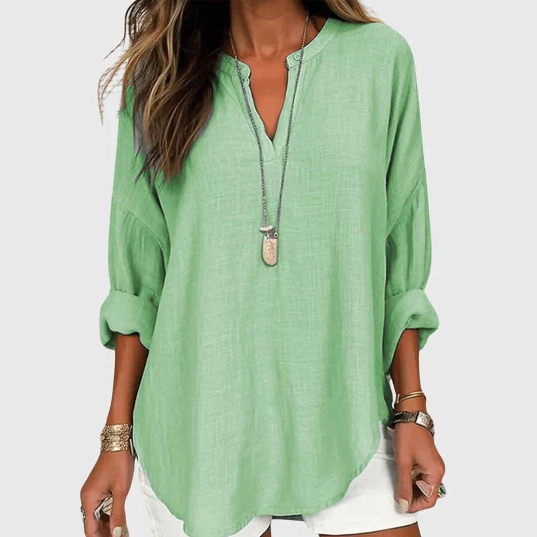 Green v-neck tunic blouse on model, side view