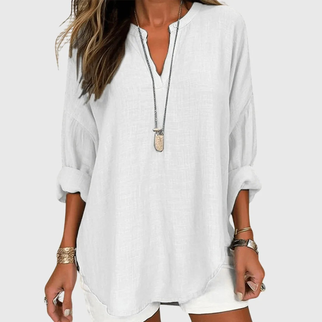 White v-neck tunic blouse on model, three-quarter turn