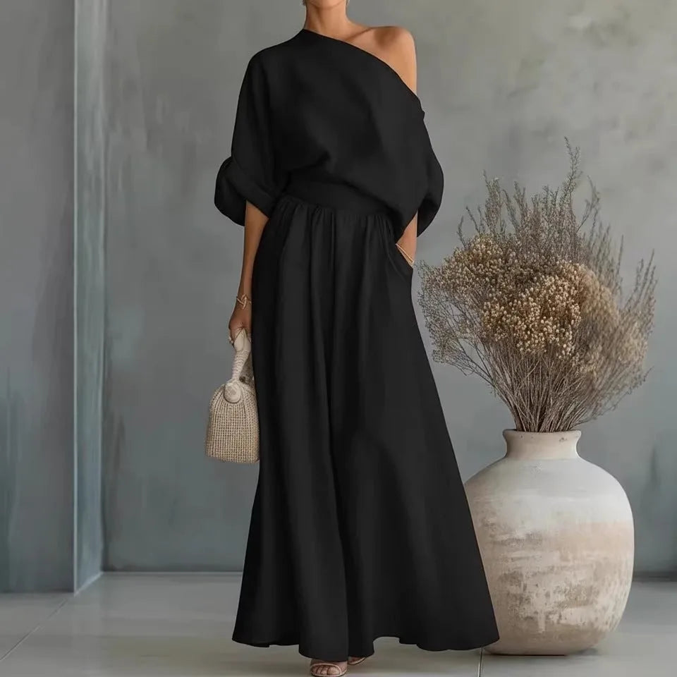 Black off-shoulder crop top and wide-leg trouser set, model shown from the side