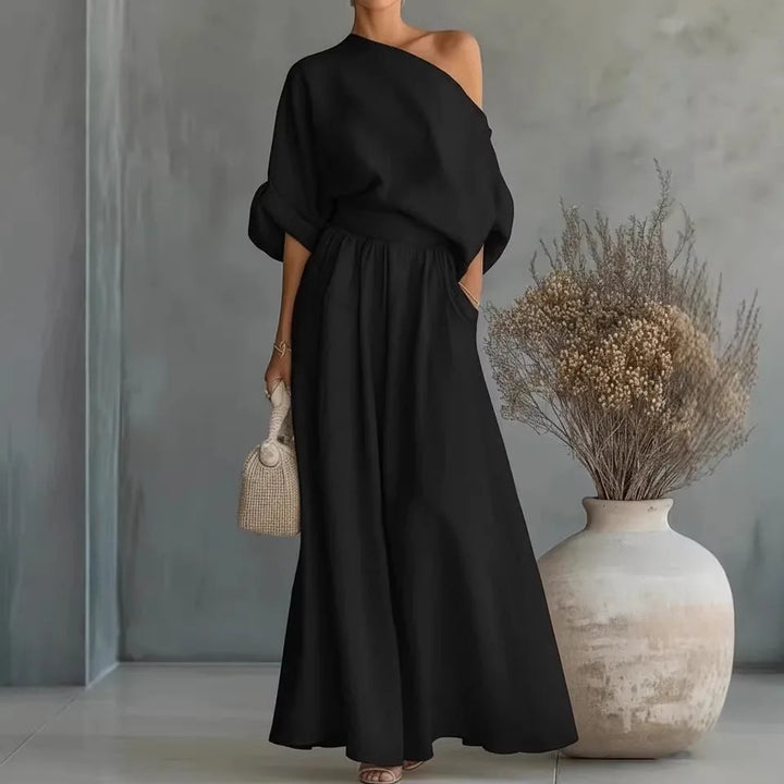 Black off-shoulder crop top and wide-leg trouser set, model shown from the side