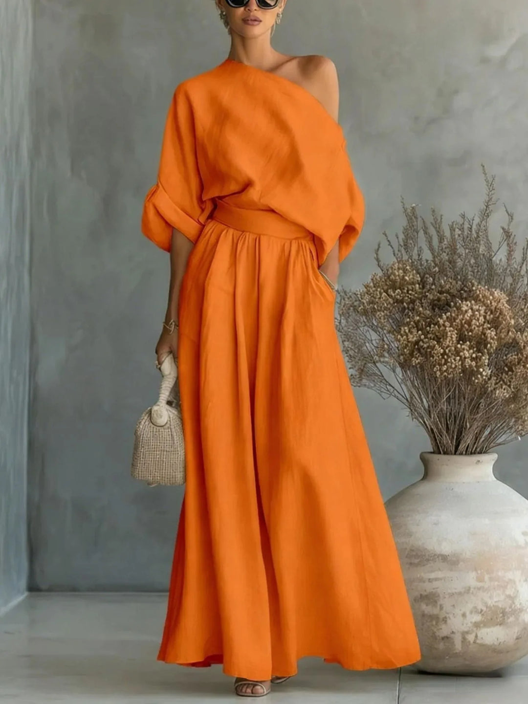 Orange off-shoulder crop top and wide-leg trouser set on standing model