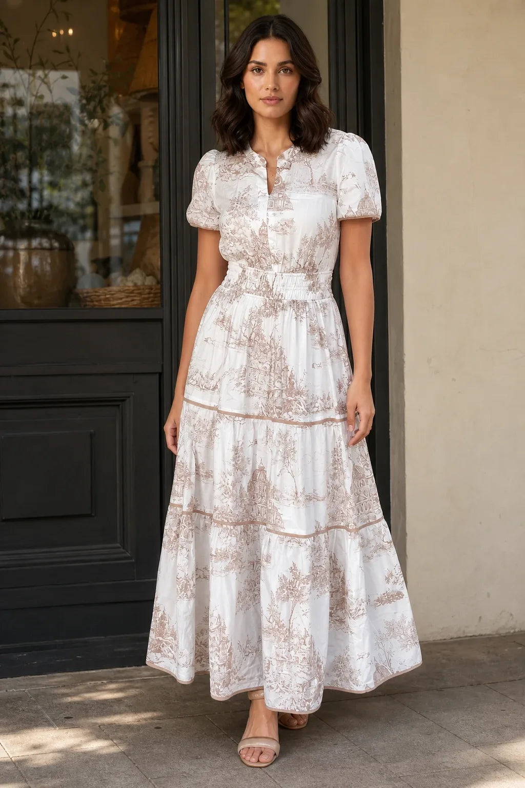 Brown tiered toile maxi dress on a model in a contrapposto stance