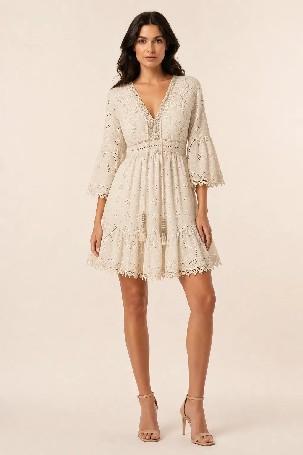 Light yellow lace eyelet mini dress on a model in a contrapposto stance