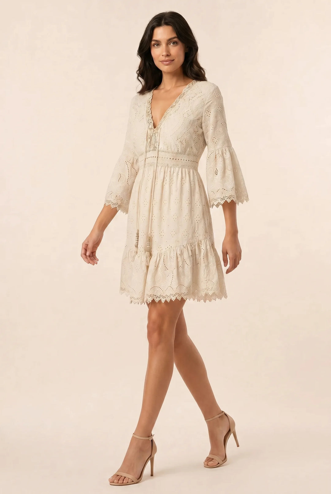 Light yellow lace eyelet mini dress on a model in a three-quarter turn