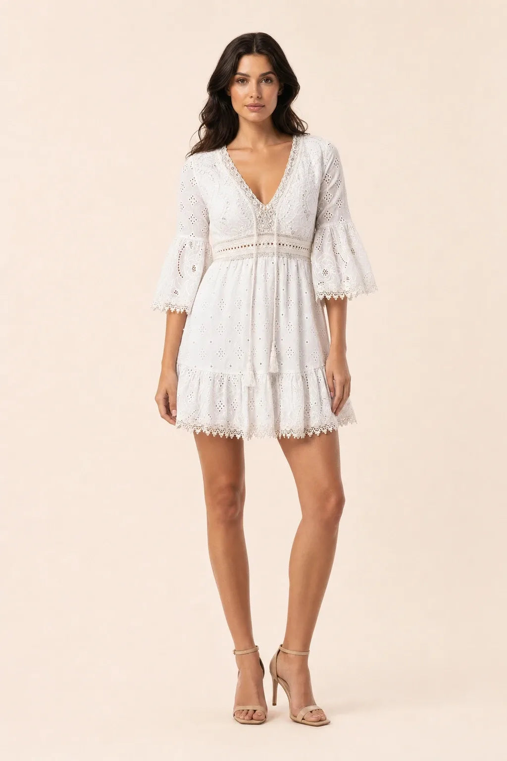 White lace eyelet mini dress on a model in a contrapposto stance