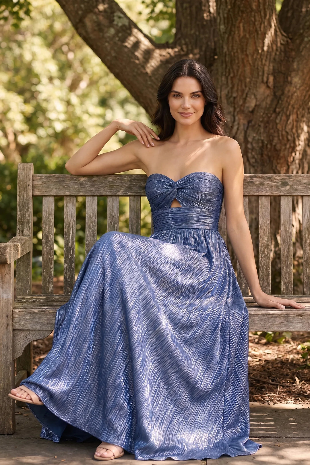 Model wearing blue twist front floor-length gown in outdoor lifestyle setting
