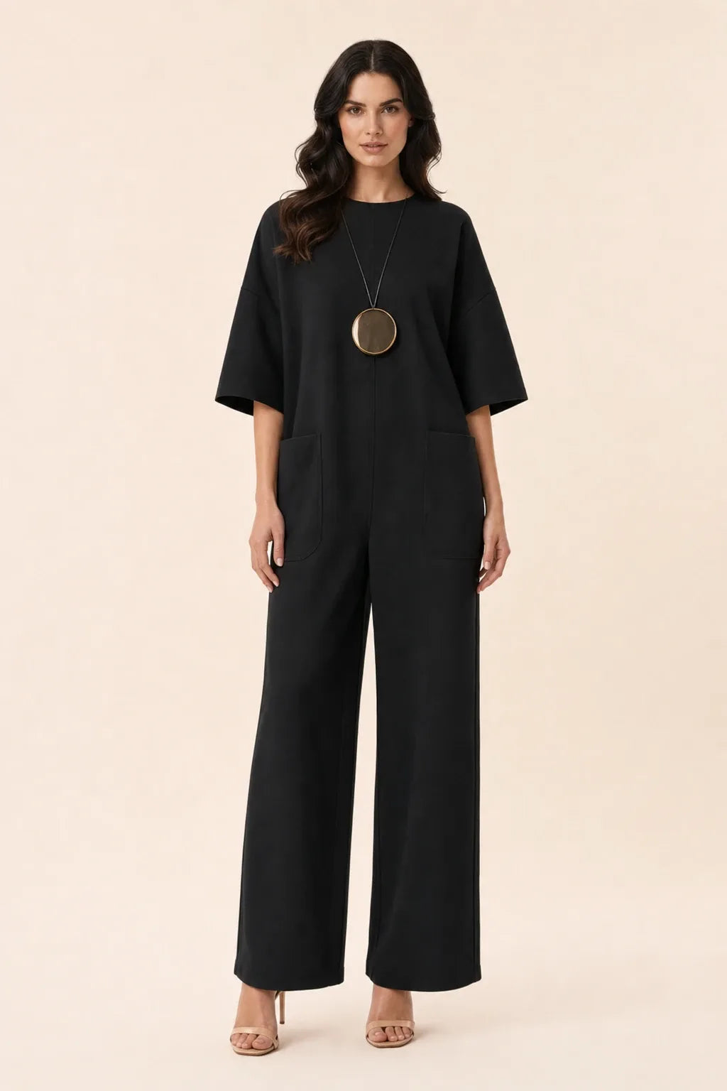Black wide-leg jumpsuit on model in contrapposto stance, front view